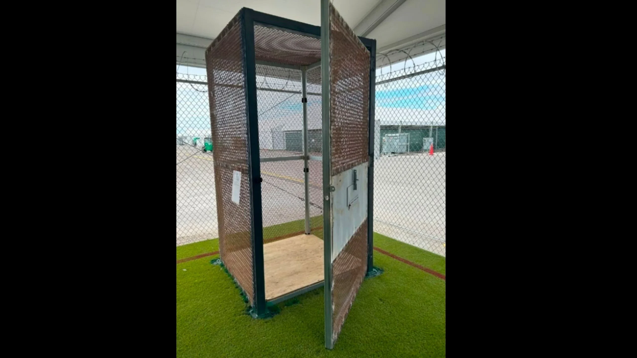 An image of a cage used at "Aligator Alcatraz," a little bigger than a phone booth with the door swung open.