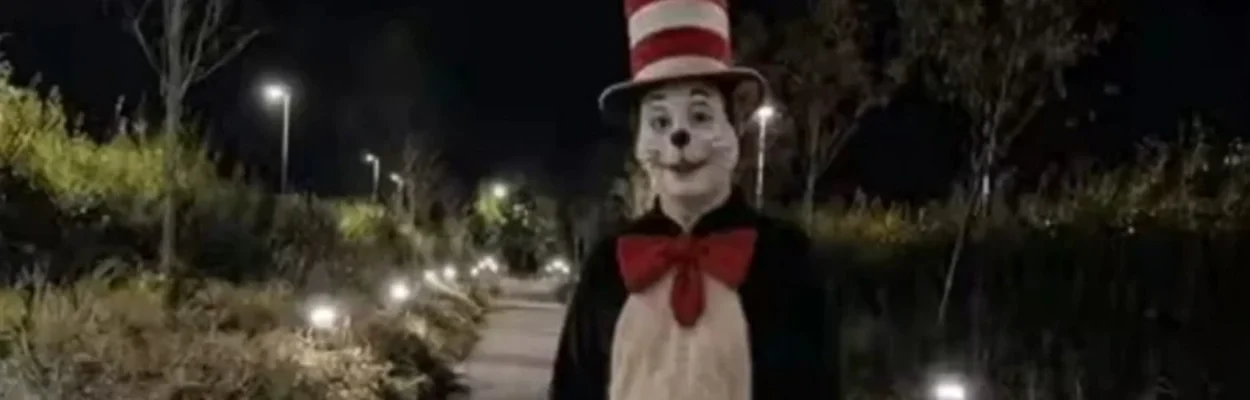 An AI-generated "Cat in the Hat" from social media. The cat stands on a lighted sidewalk in the dark.