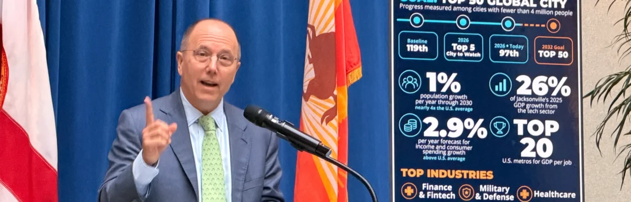 Jacksonville Civic Council President and CEO Dennis Whittle raises a finger to make a point while speaking at a lectern.