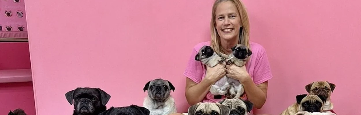 A woman surrounded by pug dogs.