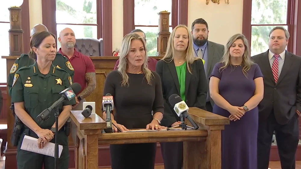 Clay County official stand in a line at a news conference, announcing a task force to target exploitive guardians.