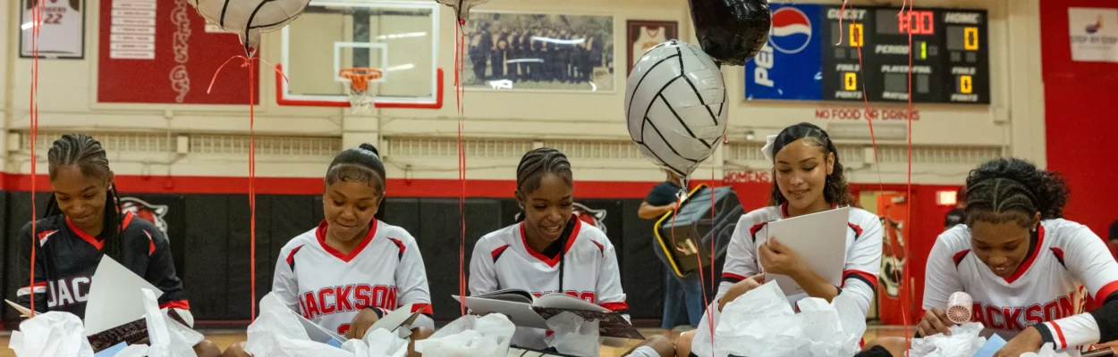 Andrew Jackson volleyball players open gift boxes.