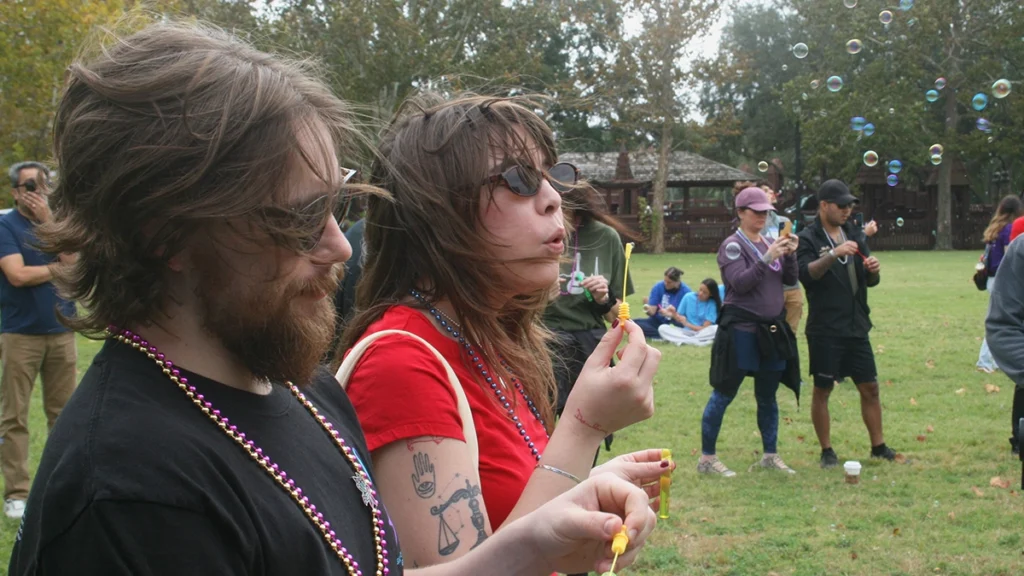 David Smart and his wife Kaileen Boccio-Smart participate in a bubble ceremony during the American Foundation for Suicide Prevention North Florida's 2026 Out of the Darkness Walk. According to the event's organizers, bubbles floating away on the breeze is emblematic of the journey to acceptance after losing a loved one to suicide.