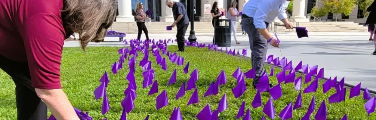 Purple flags are planted on the lawn of the Duval County Courthouse to represent injunctions filed in domestic abuse cases.