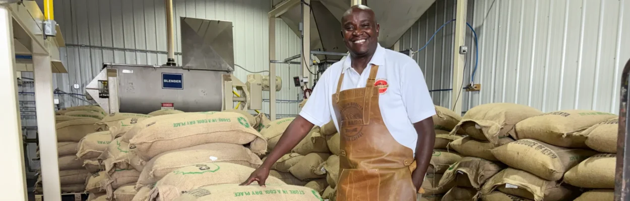 Martin Kakabi stands with 300 132-pound sacks of Kenyan coffee beans.