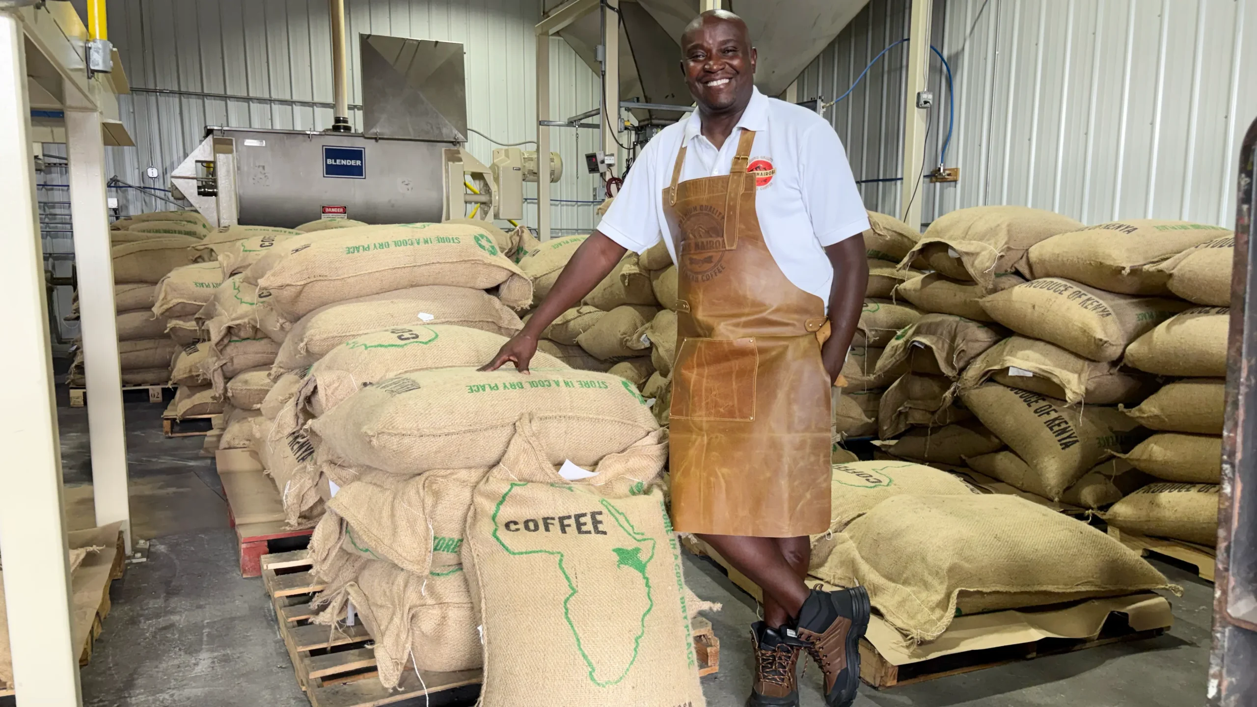 Martin Kakabi stands with 300 132-pound sacks of Kenyan coffee beans.