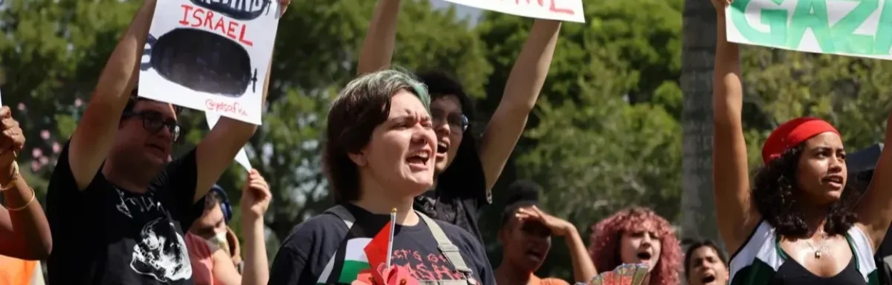 Pro-Palestinian protesters hold signs at Florida International University.