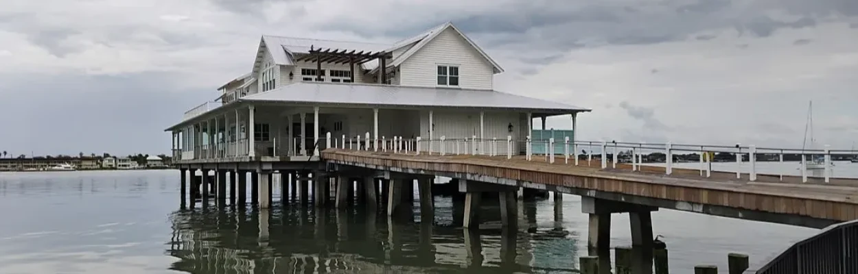 The Wharf restaurant building, shown on the water at the end of a long pier.