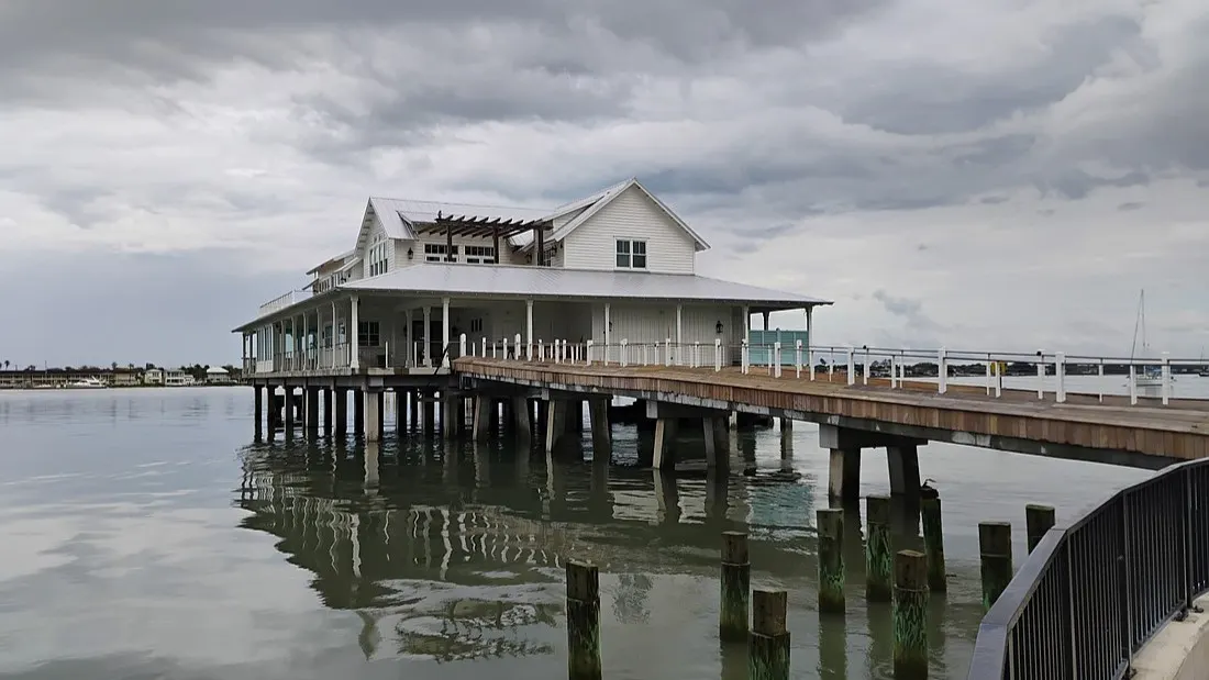 The Wharf restaurant building, shown on the water at the end of a long pier.