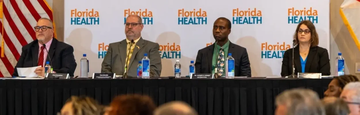 4 people on a panel listen to speakers about a proposal to remove four vaccine requirements for schools.